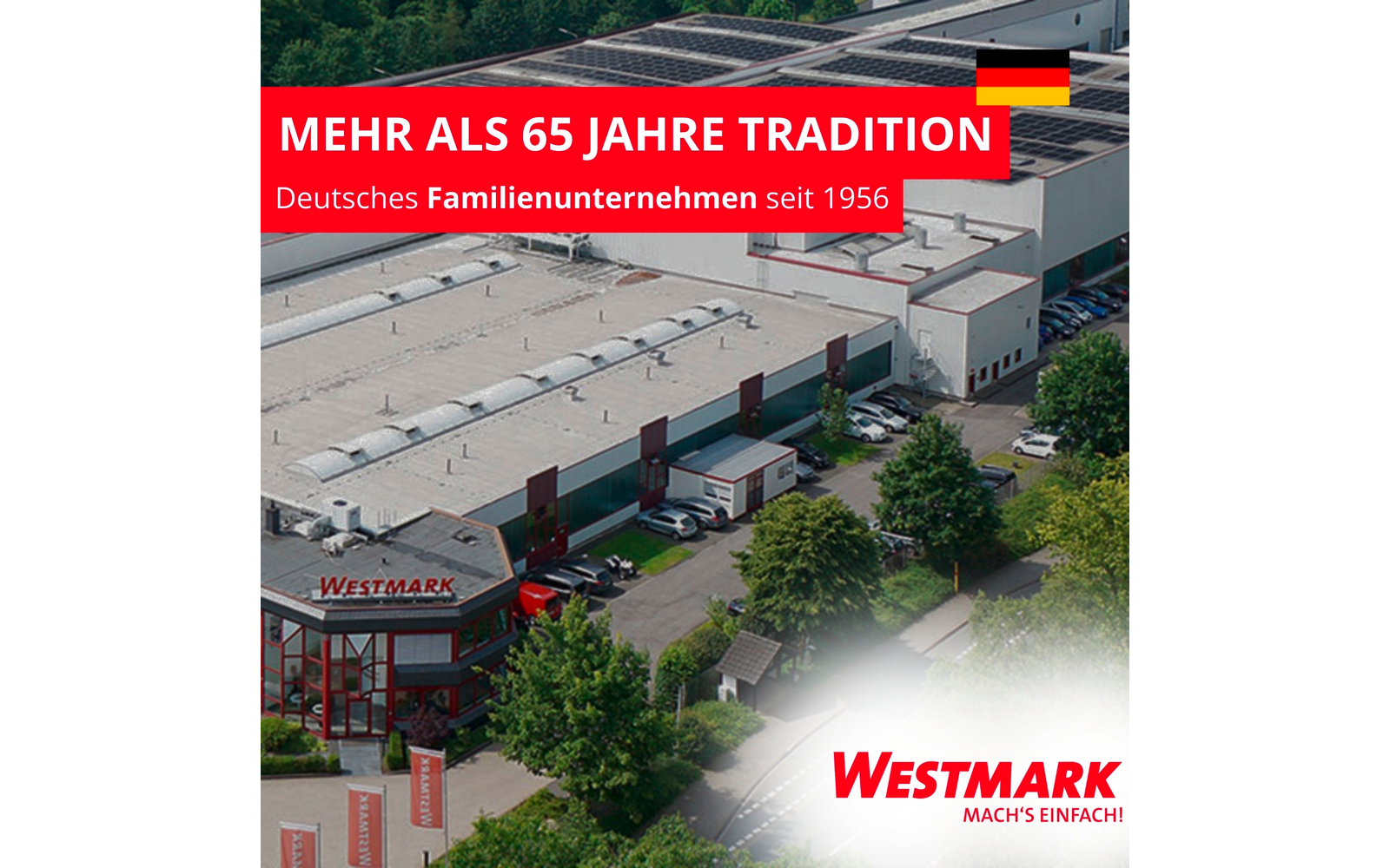 Vue aérienne d'un site d'entreprise avec toits plats, panneaux solaires, camions garés et arbres ; bande rouge en haut à gauche avec le texte MEHR ALS 65 JAHRE TRADITION et Deutsches Familienunternehmen seit 1956 et drapeau allemand ; en bas à droite zone blanche avec le logo Westmark et le slogan Mach's einfach !