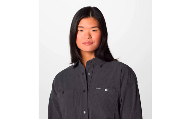 Portrait einer jungen Frau mit langen schwarzen Haaren, die eine schwarze Jacke trägt