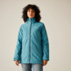 Femme aux cheveux bouclés bruns portant une veste bleue sur un fond clair