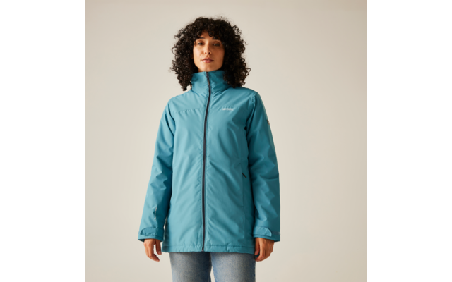 Femme aux cheveux bouclés bruns portant une veste bleue sur un fond clair
