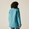 Femme vue de dos portant une veste bleue sur un fond beige