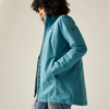 Femme aux cheveux bouclés portant une veste bleue regardant de côté