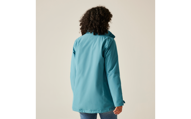 Femme vue de dos portant une veste bleue sur un fond beige