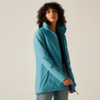 Femme aux cheveux bouclés portant une veste bleue regardant devant