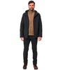 Mann mit dunklem Mantel, braunem Pullover und schwarzen Hosen steht frontal