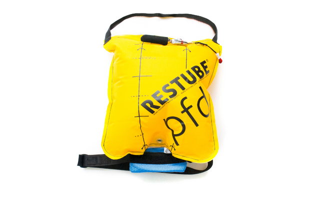 Gelbes aufblasbares Kissen mit schwarzem Schulter- und Hüftgurt, diagonal aufgedrucktem schwarzen Schriftzug "RESTUBE" und Teiltext "pfd", schwarzen Markierungen, kleinem blauen Schaumstoffpolster unten, roter Schnur, weißem Hintergrund