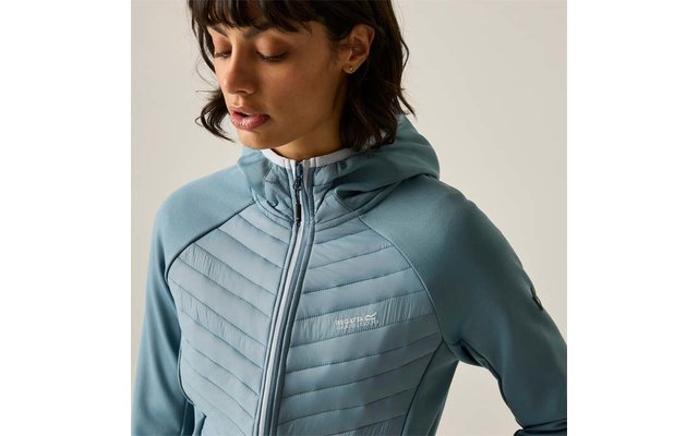 Person with short dark hair looking down, wearing light blue quilted jacket with hood, zipper and small chest logo