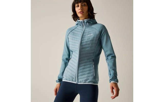 Person wearing a light blue quilted hooded jacket with full zipper and zippered pockets, dark leggings, plain background