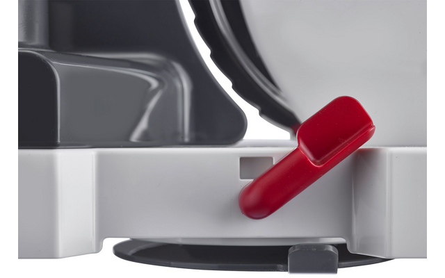 Primo piano di un involucro in plastica bianco e grigio con un disco metallico dentellato in alto a destra e una leva di plastica rossa inclinata sul davanti