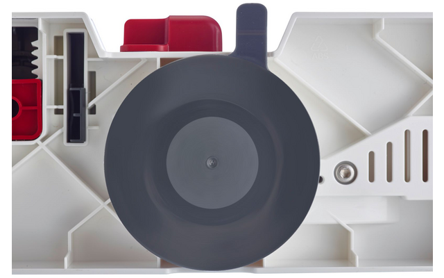 Superficie in plastica bianca con un grande disco circolare grigio al centro, parti in plastica rosse in alto a sinistra, una vite metallica a destra e strette fessure di ventilazione a destra