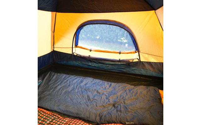 Intérieur d'une tente jaune et bleue, ouverture de fenêtre donnant sur des arbres et de l'herbe, un sac de couchage bleu foncé posé sur le sol de la tente