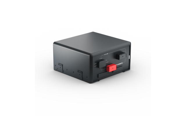Appareil électronique rectangulaire gris foncé aux bords arrondis ; face avant avec deux connecteurs rectangulaires, un rouge et un noir ; posé sur un fond gris clair