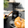 Tasse noire avec inscription sur une table, à côté d'une assiette avec des croissants