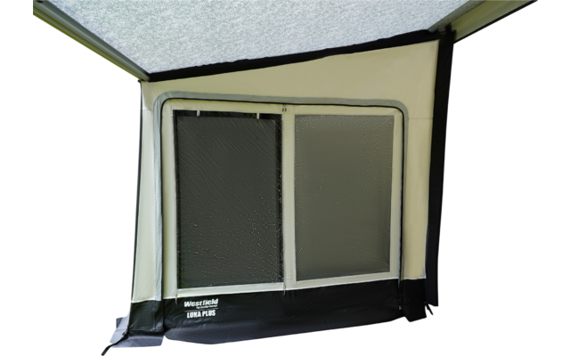 Beige Stoffwand mit weißem rechteckigem Fenster in schwarzem Rahmen; zwei nebeneinander liegende, strukturierte Scheiben; schwarzer Saum unten mit weißem Aufdruck