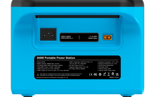 Rückseite eines blauen Geräts mit links einem Netzanschluss, mittig einem schwarzen Feld mit Spannungsangabe, rechts einem gelblichen Ausgang und darunter einem schwarzen Aufkleber mit weißem Text '300W Portable Power Station' und technischen Angaben