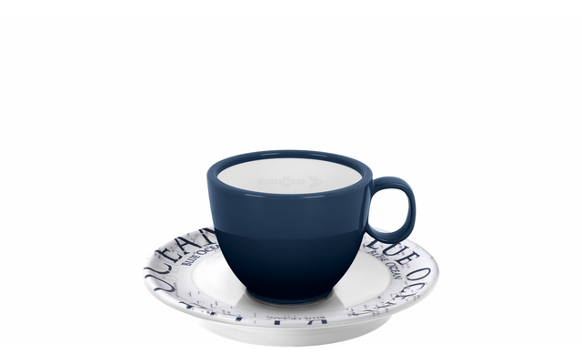 Tasse bleu foncé avec anse, remplie d'un liquide blanc, sur une soucoupe blanche avec lettres bleues, fond blanc