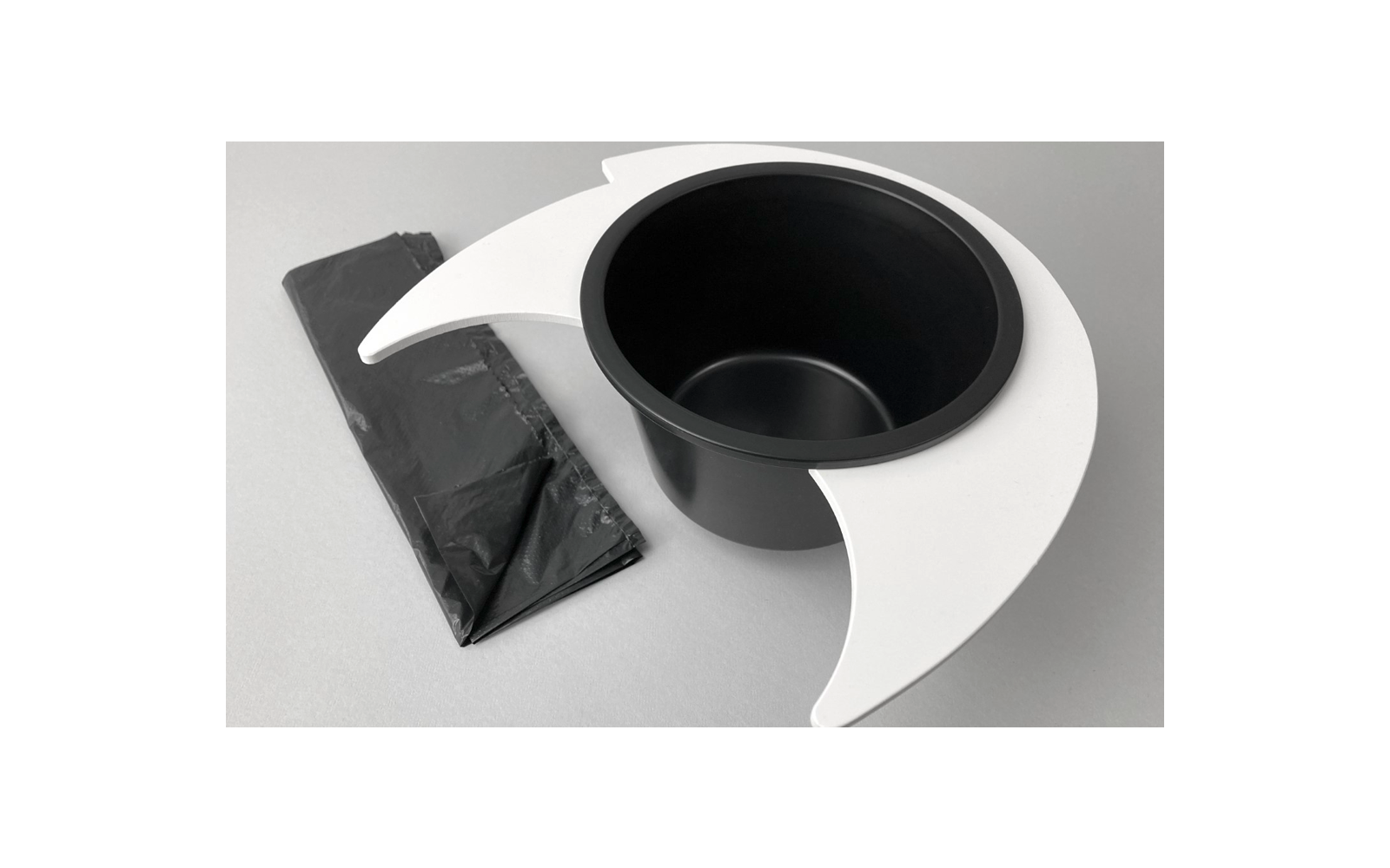 Sac noir et seau noir avec support blanc sur surface grise