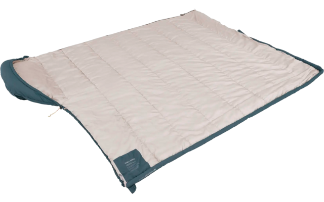 Beige gewatteerd deken met donkergroene rand liggend op een witte achtergrond