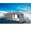 Wohnmobil mit grauer Abdeckung auf verschneiter Bergstraße, schneebedeckte Berge und blauer Himmel im Hintergrund