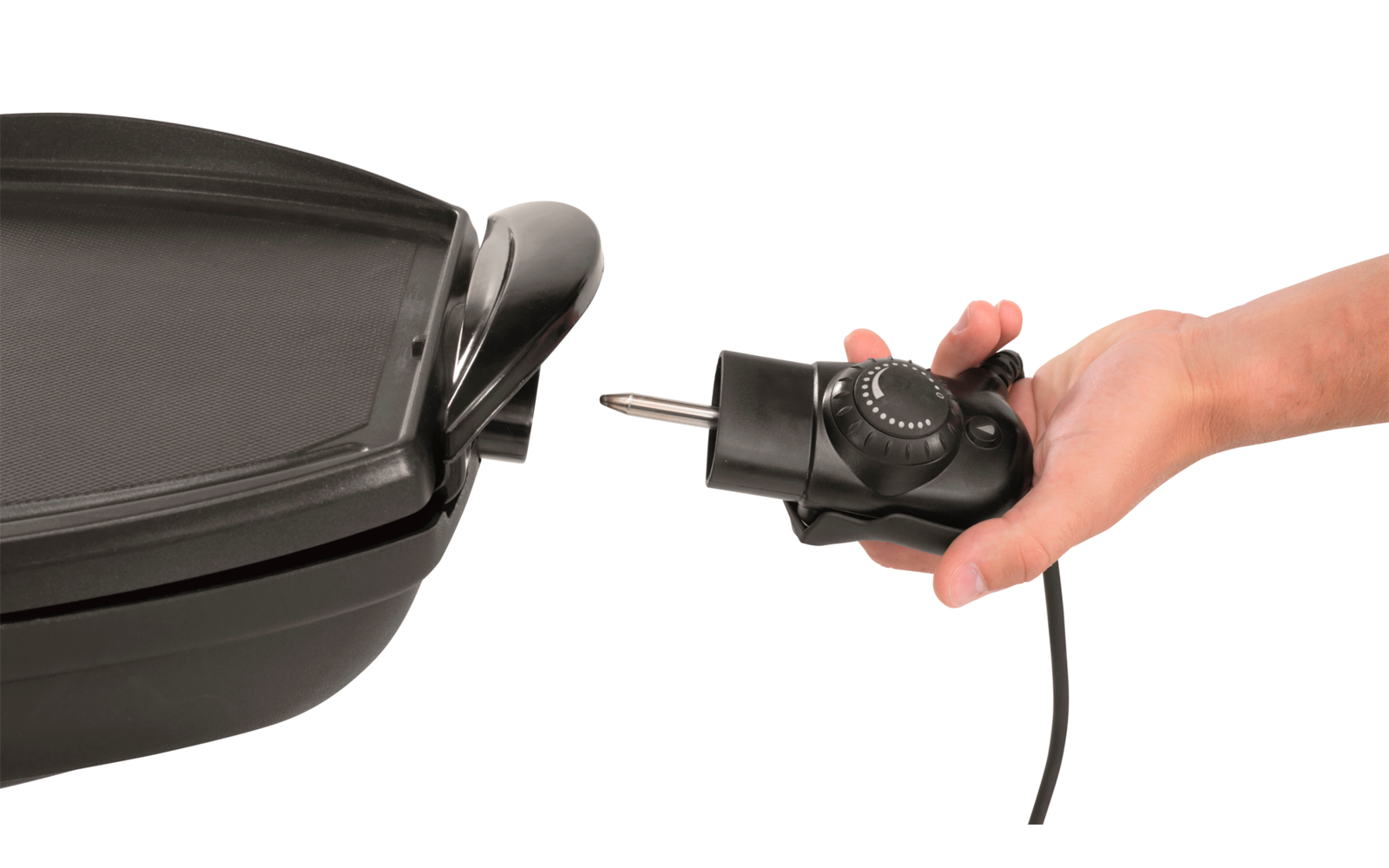 Eine Hand hält einen schwarzen Temperaturregler, der an eine schwarze elektrische Grillpfanne angeschlossen ist