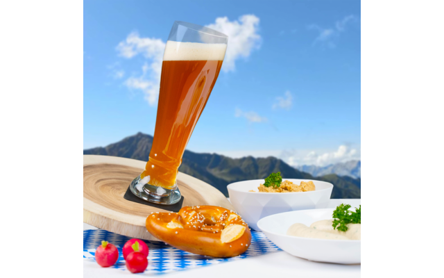 Bierglas, Brezel, zwei kleine Schalen mit Essen und drei Radieschen vor Bergpanorama