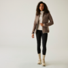 Femme portant un blazer marron clair, un pull blanc, un pantalon noir et des bottes claires sur un fond clair