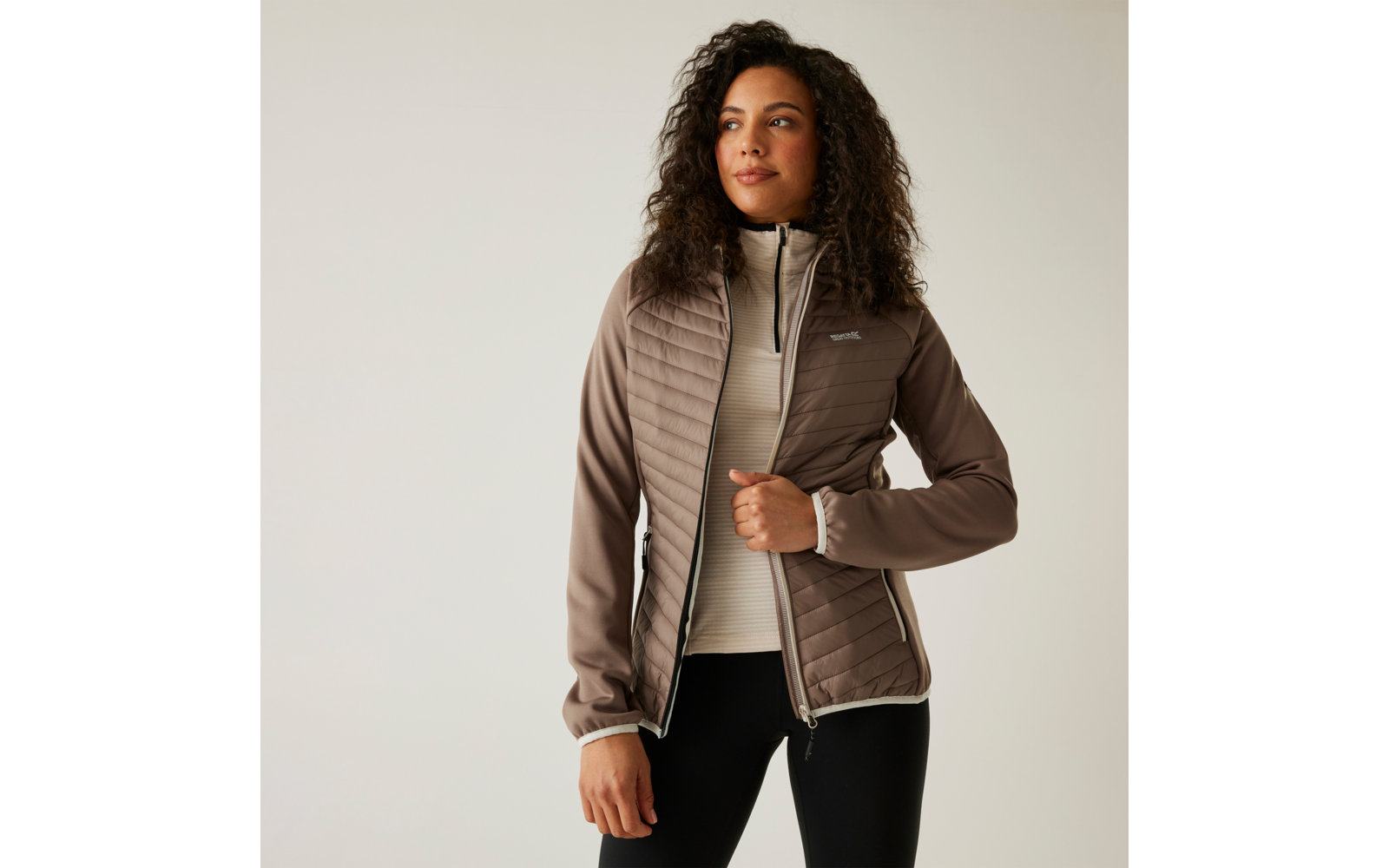 Jeune femme portant une veste matelassée marron et un pantalon foncé