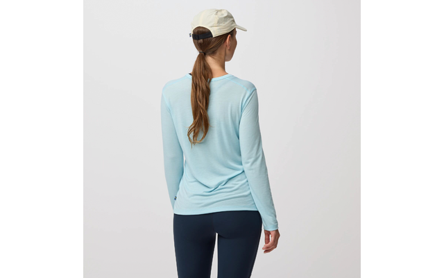 Persona vista de espaldas, lleva una camiseta de manga larga azul claro, mallas oscuras y una gorra beige, pelo largo recogido en una coleta