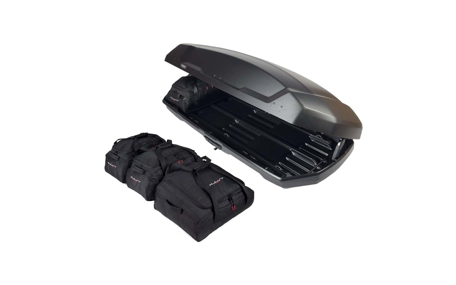 Offene schwarze Dachbox mit sichtbarem Innenraum, daneben drei schwarze Reisetaschen
