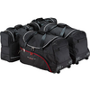 Trois sacs de voyage noirs à roulettes avec poignées supérieures et fermetures éclair ; un sac présente une bordure rouge