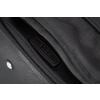 Gros plan d'une fermeture éclair noire sur un sac, partiellement ouverte, avec une tirette en plastique noir portant l'inscription 'PUSH' et tissu texturé