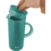 Hand met bruine gebreide mouw tilt het deksel van een groene kan met handvat; Berger-logo vooraan onderaan