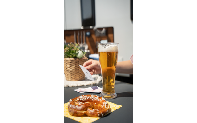 Een glas bier en een belegde sandwich op een houten tafel buiten