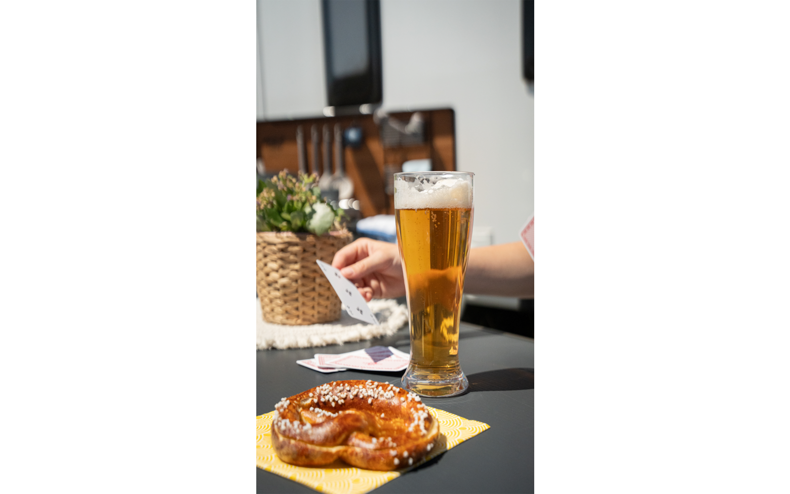Een glas bier en een belegde sandwich op een houten tafel buiten