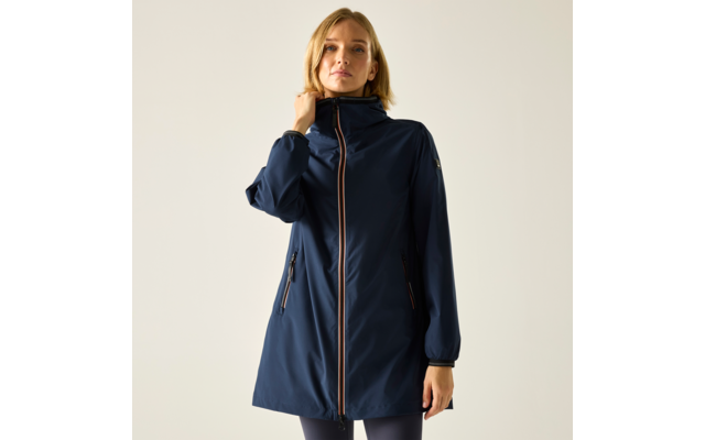 Person trägt lang geschnittene dunkelblaue Regenjacke mit durchgehendem Reißverschluss, Kapuze und seitlichen Reißverschlusstaschen; linke Hand berührt den Kragen; heller einfarbiger Hintergrund