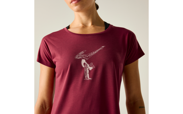 Oberkörper einer Person bis zum Kinn, trägt ein dunkelrotes T‑Shirt mit schwarzem Einsatz am Halsausschnitt. Auf der Brust ein kleines weißes Linienmotiv mit zwei stilisierten Figuren, eine nach vorn geneigt und eine waagrecht darüber