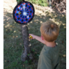 Ein Junge steht vor einem Baum, an dem eine Dartscheibe befestigt ist