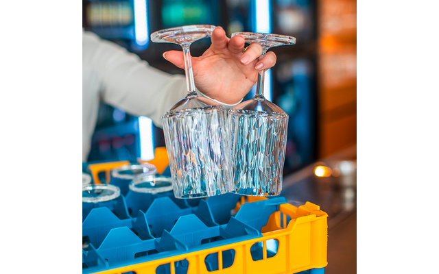 Hand hält ein Glas unter einen Wasserauslauf in einer Bar