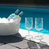 Eiswürfelbehälter mit zwei Flaschen und zwei leere Gläser auf blauem Untergrund