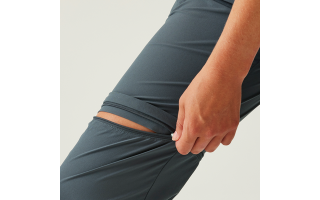 Hand zieht den Bund einer dunkelgrauen Sporthose nach unten, innerer Hosenbund sichtbar