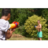 Zwei Kinder spielen mit Wasserpistolen im Garten, umgeben von Büschen