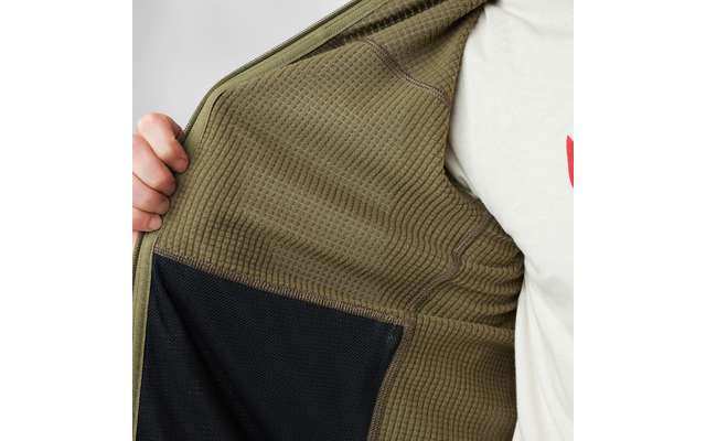 Hand hält offene olivgrüne Jacke; sichtbares strukturiertes Innenfutter, schwarzes Innenfach und Teil eines weißen T-Shirts mit rotem Aufdruck