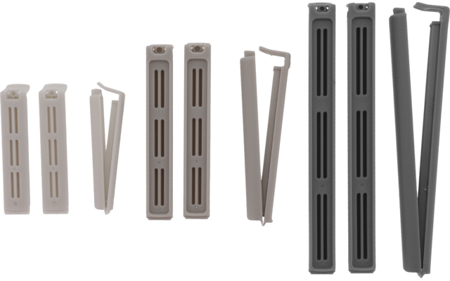 Reihe länglicher Kunststoffteile mit rechteckigen Schlitzen in hellbeige und braun, daneben mehrere dünne Stäbe