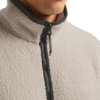 Nahaufnahme von Kinn, Hals und Oberkörper in einer beigen Teddy-Fleecejacke mit schwarzem Reißverschluss und Kordel