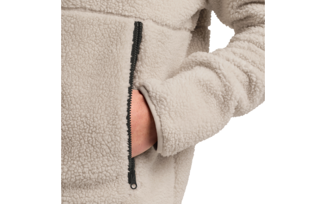 Hand in Reißverschlusstasche einer hellbeigen Fleecejacke