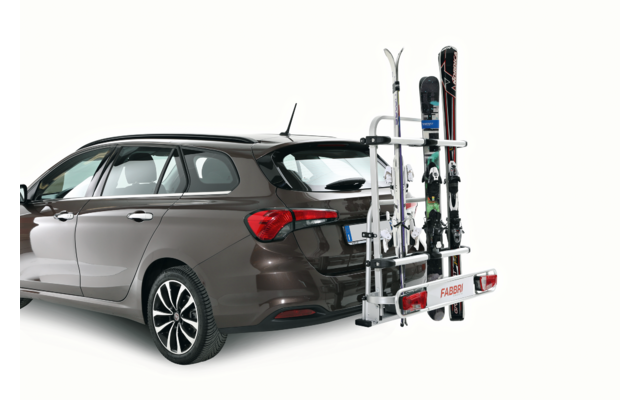 Station wagon marrone vista da dietro a sinistra, con un portasci montato sul gancio di traino con più sci e una tavola da snowboard