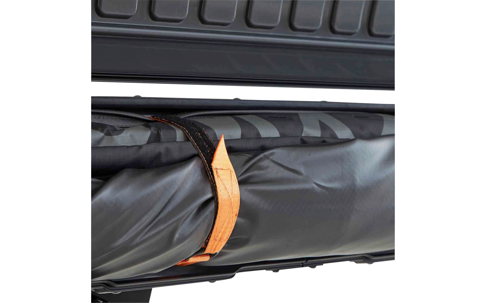 Innenseite eines geöffneten schwarzen Hartschalenkoffers, darin ein gerollter schwarzer Stoffgegenstand mit einer orangefarbenen Schlaufe