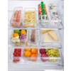 Drei transparente Behälter mit unterschiedlichen Lebensmitteln, darunter Wurst, Käse, Obst und Gemüse, auf einem Holztisch