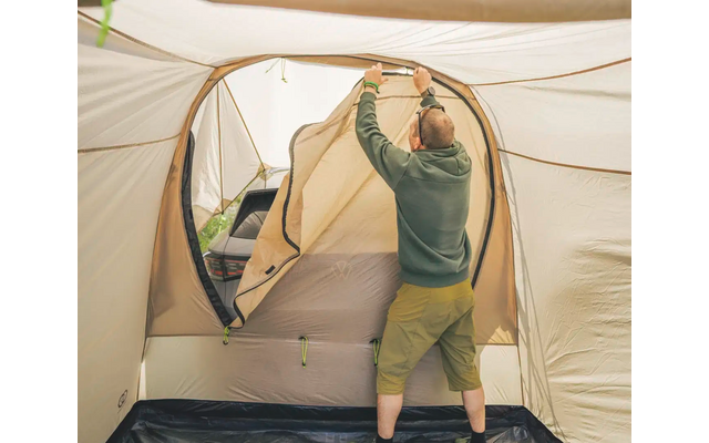 Person im Zelt, die das Zeltfenster öffnet