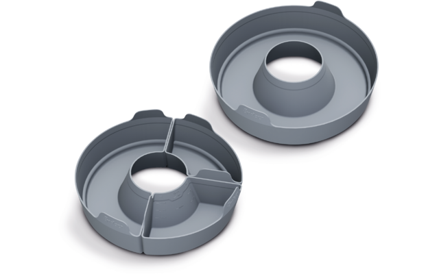 Zwei runde graue Formteile mit erhöhtem mittigem Zylinder; eines ist in vier Segmente unterteilt; auf weißem Hintergrund